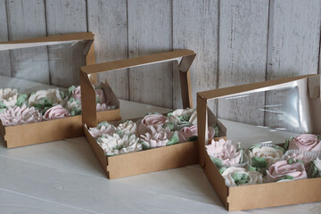 Fototapeta na wymiar Zephyr flowers. Homemade marshmallows in paper gift boxes. The boxes is open. View from above.