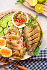Rice with fried gourami fish with boiled egg and cucumber with thai style sauce ,top view table