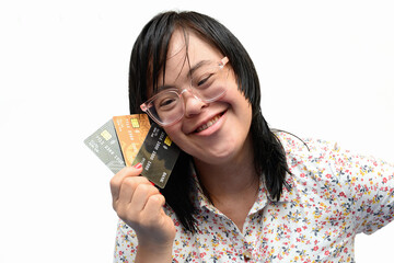 Beautiful young woman with Down syndrome very happy with various credit cards.Payment for goods via credit card. Financial and banking concept. Trisomy 21