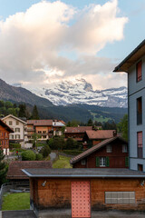 Buildings at Sunset in the Swiss Alps in Switzerland in the Summer With Mountains Peaking Through the Clouds in the Background 