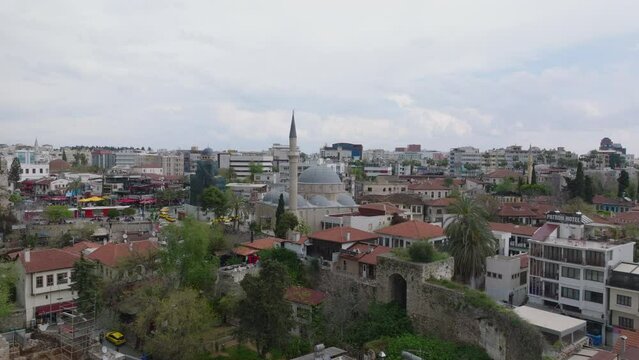 Aerial ascending footage of historic monuments in old town district. Tekeli Mehmet Pasa Mosque with slim tall minaret. Antalya, Turkey