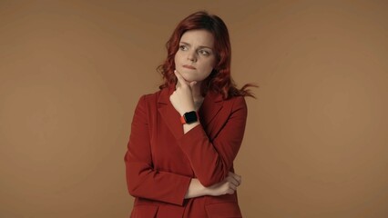 Medium isolated shot of a young woman pensively looking away and trying to come up with an idea, while touching her chin and biting her lips.