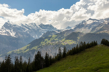 Swiss Alps in Switzerland in the Summer with Mountains Peaking Through Clouds in the Background