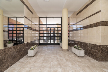 Access portal to a residential building with white flower pots