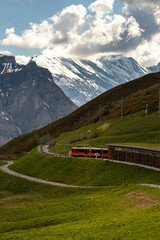 Train Traveling Up the Mountain in the Swiss Alps in the Summer with Mountains in the Background in Switzerland