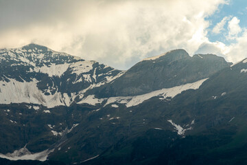 Close Ups of Mountains of the Swiss Alps in Switzerland in the Summer at Sunset with the Mountains Peaking Through Clouds