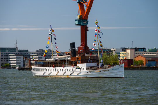Gothenburg, Sweden - June 03 2023: Old tourist ship Bohusl?n with testive signal flags steaming up the river.
