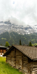 Buildings Sitting Along the Hills high up in the Swiss Alps with mountains in the background in Switzerland in Summer