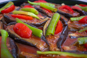 Baked eggplant stuffed with ground beef, tomatoes and green peppers on a tray. Traditional delicious Turkish food. Riven belly - Karniyarik. Turkish cuisine. Aubergine eggplant meal. Close up