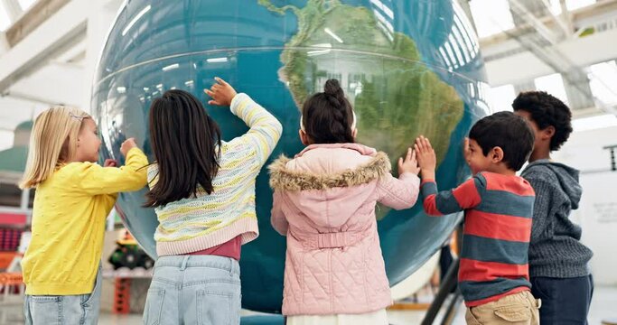 World, map and children learning with a globe in classroom, education or study geography in school with exited students. Kids, group and teaching students about planet, earth and countries on sphere