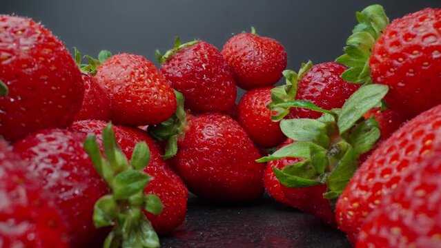 Ripe juicy strawberry. Healthy organic food. Fresh strawberries. Camera moving through heap of strawberries. Dolly shot using probe lens. Slide out. Red berries. Close-up in 4K, UHD