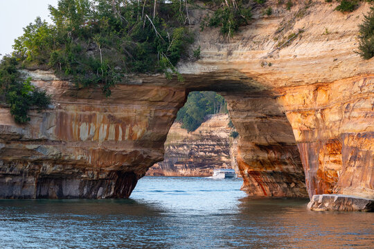 Catamaran along Pictured Rocks National Lakeshore viewed through a natural arch
