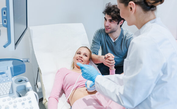 Couple in reproduction clinic being happy as the wife is pregnant as revealed by ultrasonic examination