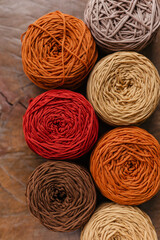 Large cotton threads on a textured wooden table, top view