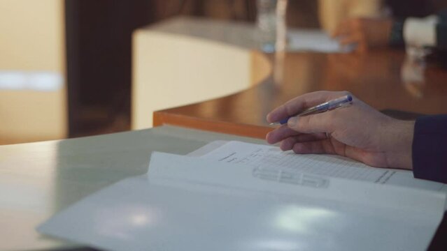 Hands writing on paper or marks sheet