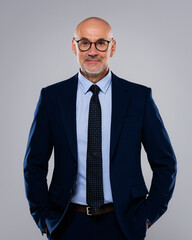 Portrait of a middle-aged businessman standing against a grey background