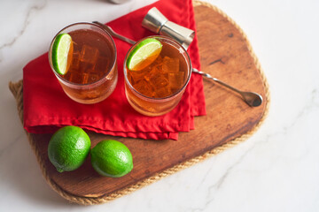 long island iced tea cocktail with strong drinks, cola, lime and ice in glass, cold longdrink or lemonade