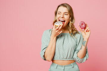 Young cool fun smiling cheerful satisfied happy woman she wearing casual clothes eating tasty...
