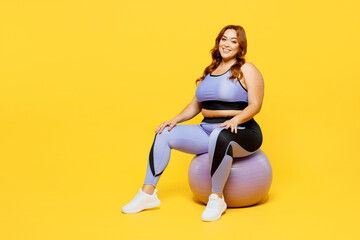 Full body smiling happy young chubby plus size big fat fit woman wear blue top warm up training sit...