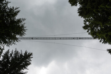 silhouettes of people on a suspension bridge