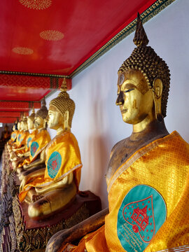 A series of golden Buddha statues in a temple.