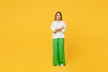 Fototapeta na wymiar Full body young confident smiling caucasian happy woman she wears white shirt casual clothes hold hands crossed folded lok camera isolated on plain yellow background studio portrait Lifestyle concept