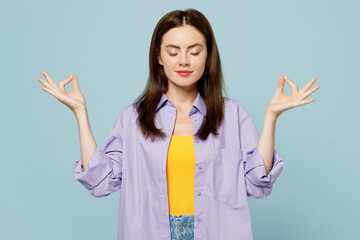 Young spiritual happy woman wears purple shirt yellow t-shirt casual clothes hold spreading hands...