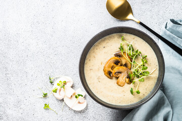 Mushroom Soup on light stone table. Champignon cream soup with herbs. Top view with copy space.