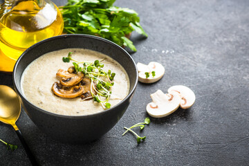 Mushroom Soup on dark stone table. Healthy vegan dish. Autumn soup.