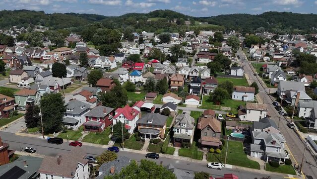 A high wide aerial establishing shot view of a typical middle-class rust belt residential neighborhood in summer. Densely packed homes. Pittsburgh suburbs.  	