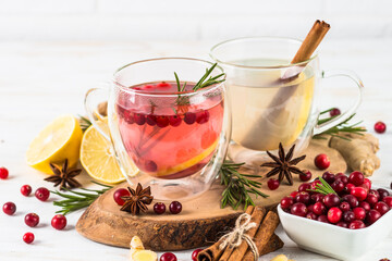 Cranberry tea and ginger tea with lemon and spices in glass mugs. Healthy hot vitamin drink.