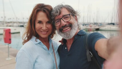 Close-up of smiling family couple taking selfie while standing in marina on yacht background