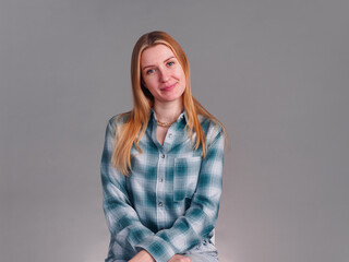 Obraz premium Beautiful smiling woman with natural makeup wear fashion clothes looking friendly on gray background.