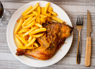 Spicy bbq chicken legs with with boiled potato close-up on a plate