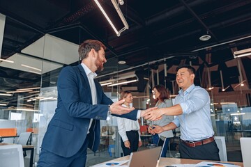 colleagues are shaking their hands in modern office during teamwork. High quality photo