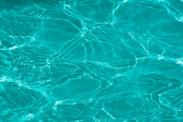 Obraz premium Blue water with ripples on the surface. Defocus blurred transparent blue colored clear calm water surface texture with splashes and bubbles. Water waves with shining pattern texture background.