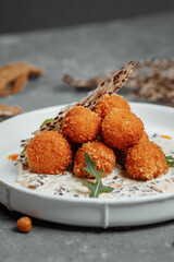Potato croquettes - mashed potatoes balls breaded and deep fried, served with different sauce.