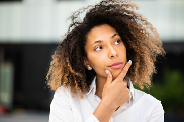Fototapeta na wymiar Confident young afro american female manager outdoor in a pensive expression