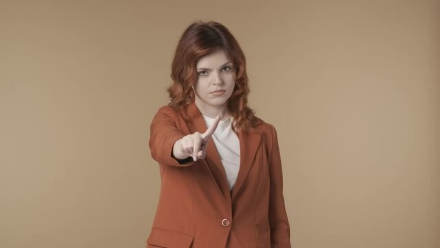 Medium isolated video of a young woman pointing at the camera and negatively wagging her finger to show her disagreement, complaint about something. HDR BT2020 HLG Material. HDR BT2020 HLG Material.