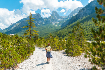 Woman hikers walking in Valbona valley next to trees, Theth national park, Albanian Alps, Albania