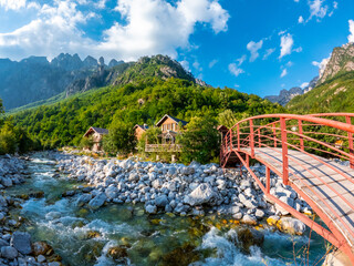 Red bridge along the river of Valbona Valley and some wooden houses or lodges, Theth National Park, Albanian Alps, Albania