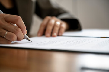 Closeup view of female hands signing a document or contract - 643343121