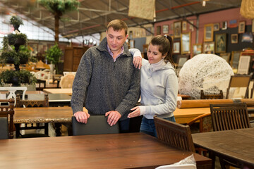 Portrait of young man and woman looking for furniture at showroom