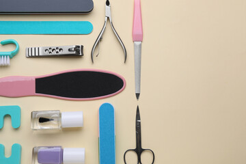 Set of pedicure tools on beige background, flat lay. Space for text
