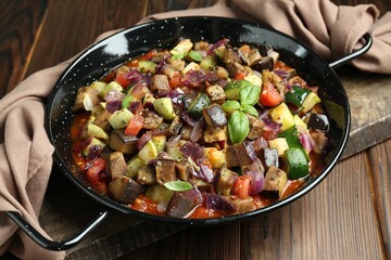 Delicious ratatouille in baking dish on wooden table, closeup