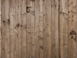 Wooden wall texture out of timber planks. Woodgrain pattern of vertical boards in brown color. Pattern of a building exterior or a fence.