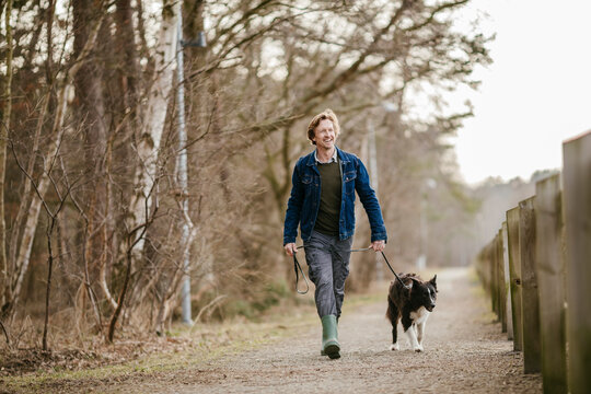 Middle aged man walking his dog in nature