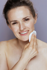 smiling modern woman with cotton pad on blue