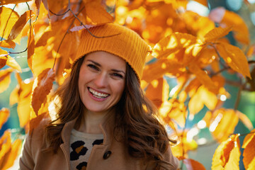 happy trendy woman in brown coat and yellow hat