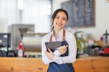 Portrait of young Happy asian business woman cafe owner in an apron with tablet, Asian CAFE Small business concept,